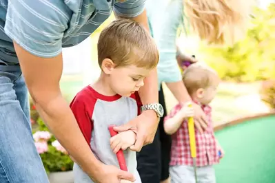 family playing mini golf